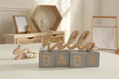 Decorative phrase Hello Baby on white table in child room. Interior design