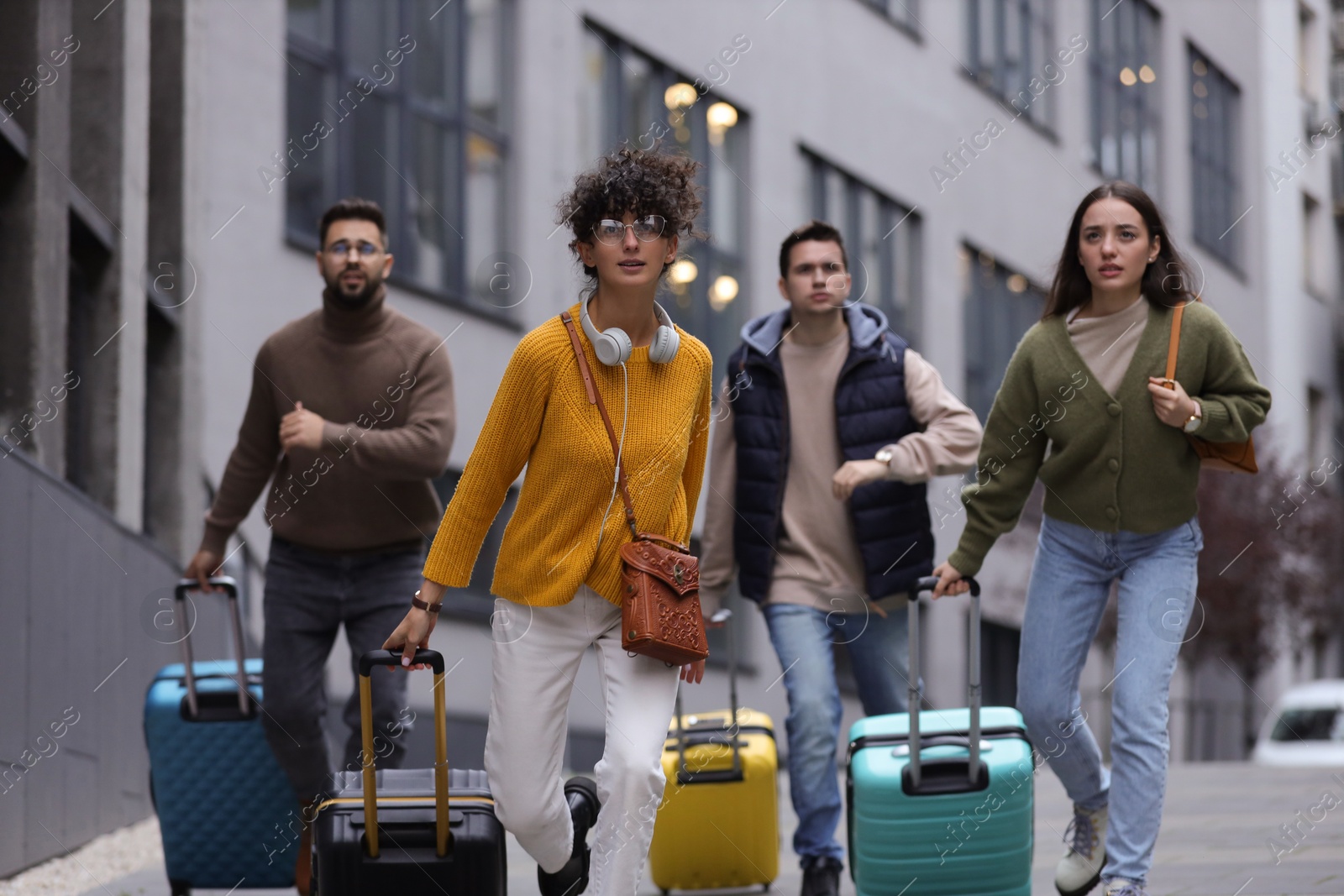 Photo of Being late. Group of people with suitcases running outdoors