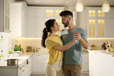 Lovely young couple dancing in kitchen. Cooking together