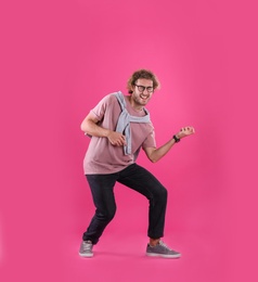 Photo of Young man playing air guitar on color background