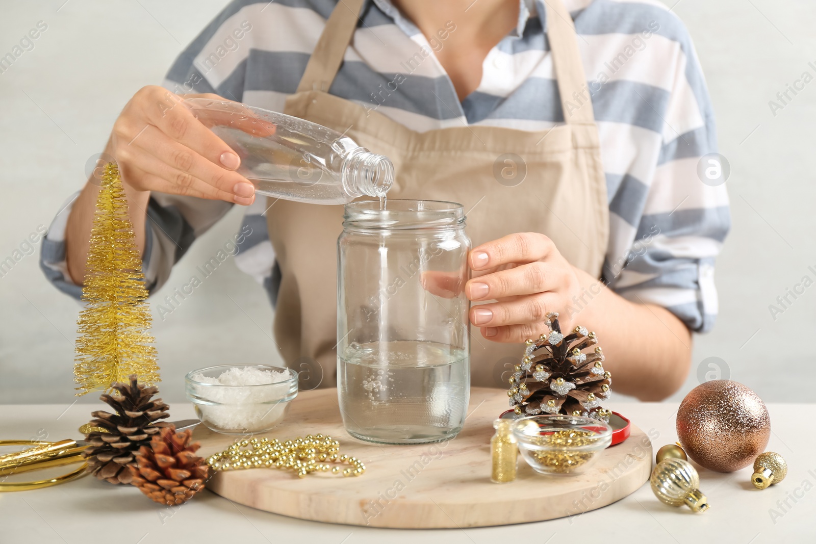 Photo of Woman making snow globe at light table, closeup