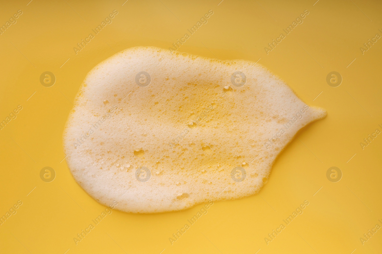 Photo of Sample of fluffy foam on yellow background, top view