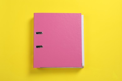 Photo of Pink office folder on yellow background, top view