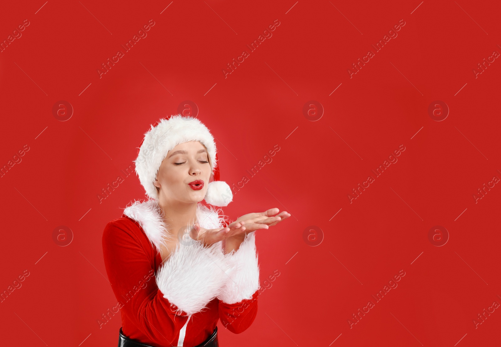 Photo of Beautiful Santa girl on red background, space for text. Christmas eve