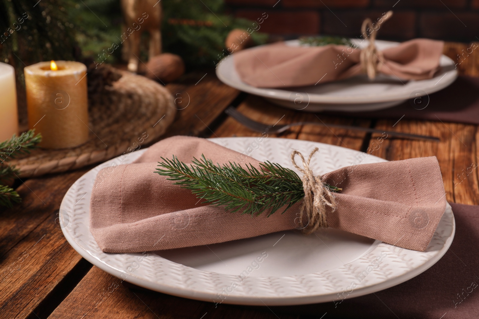 Photo of Festive place setting with beautiful dishware and fabric napkin for Christmas dinner on wooden table