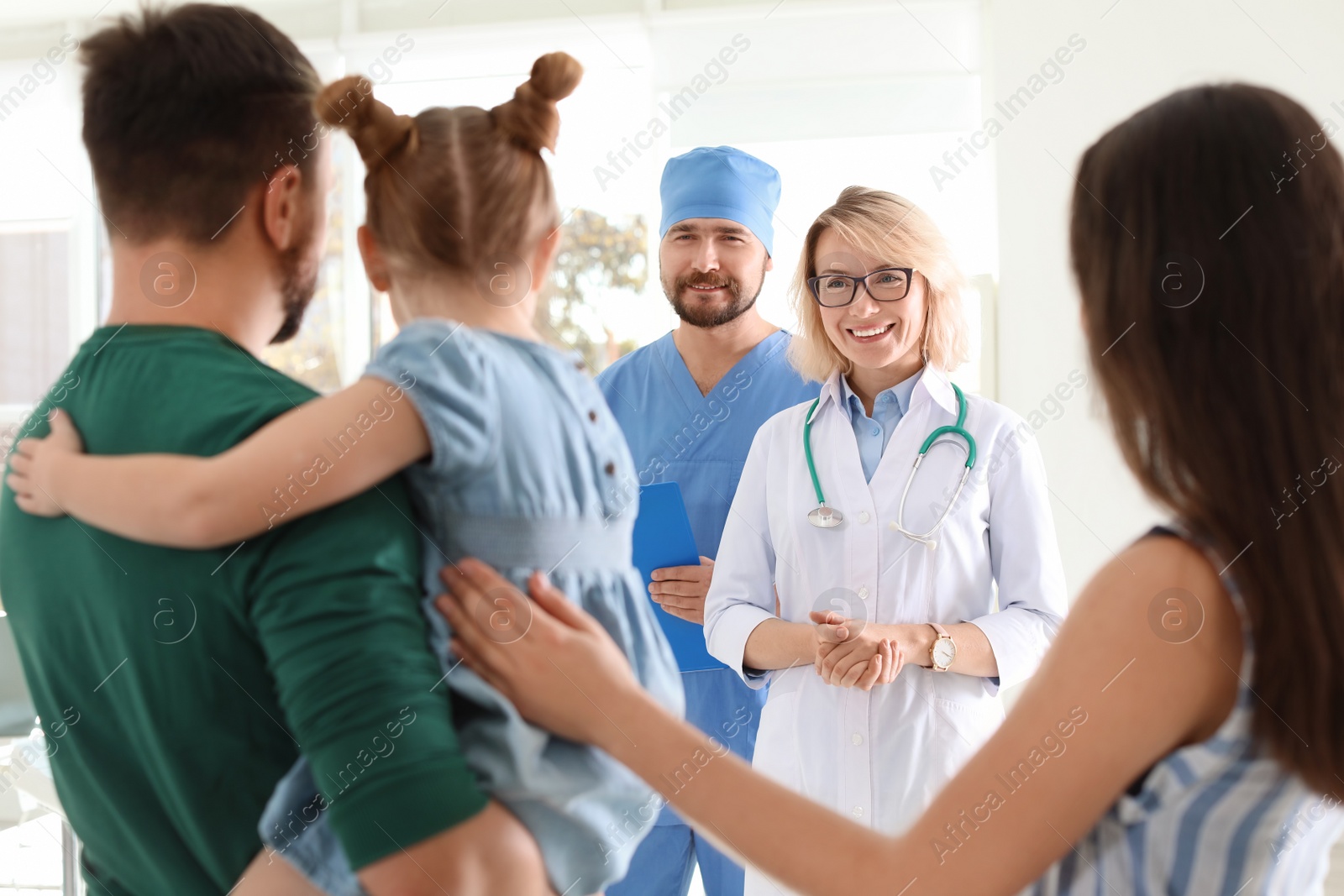 Photo of Little girl with parents visiting children's doctors in hospital