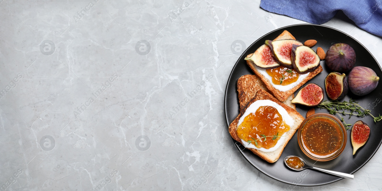 Photo of Tasty toasts with fig jam and cream cheese on grey marble table, flat lay. Space for text