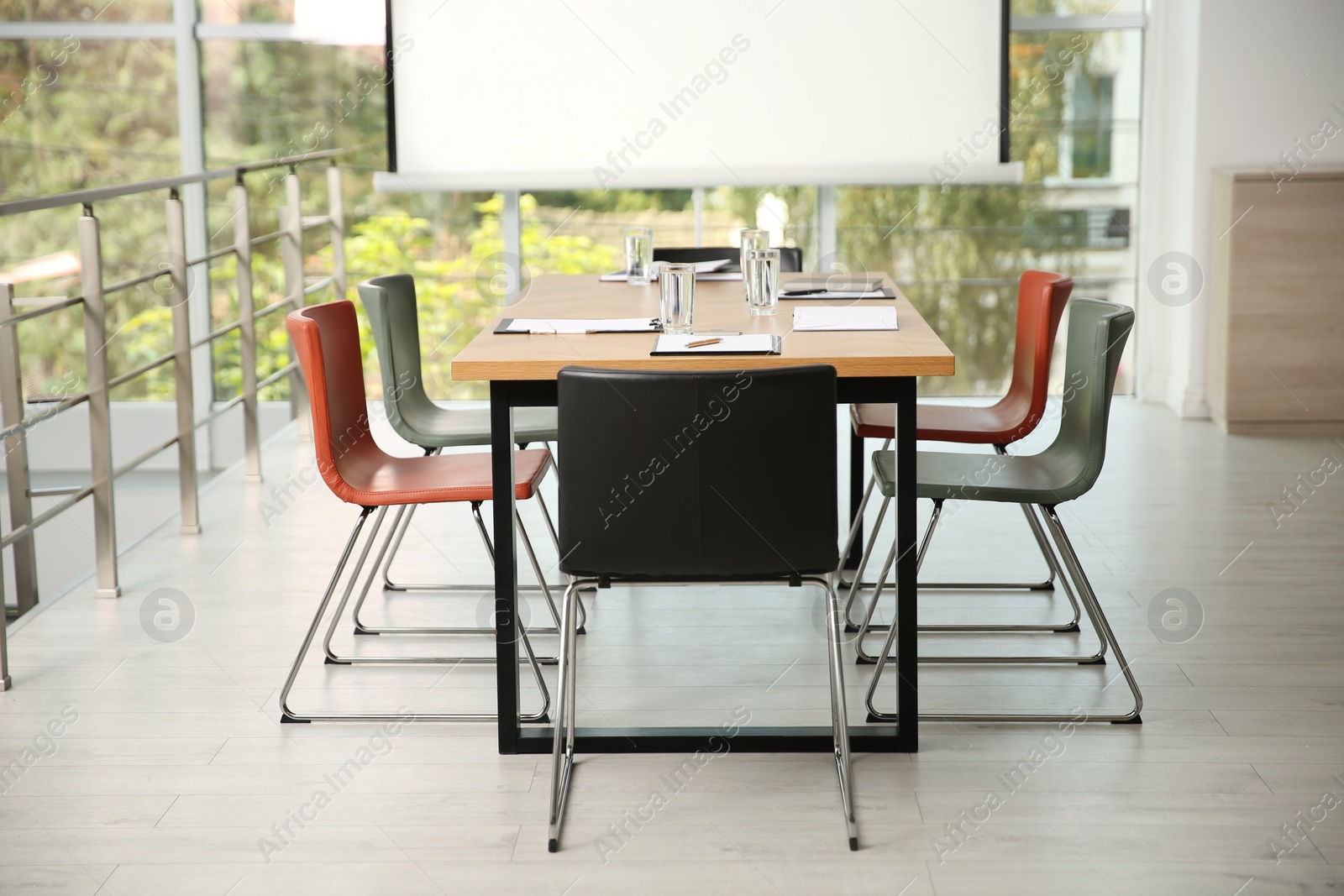 Photo of Modern meeting room interior with large table and projection screen