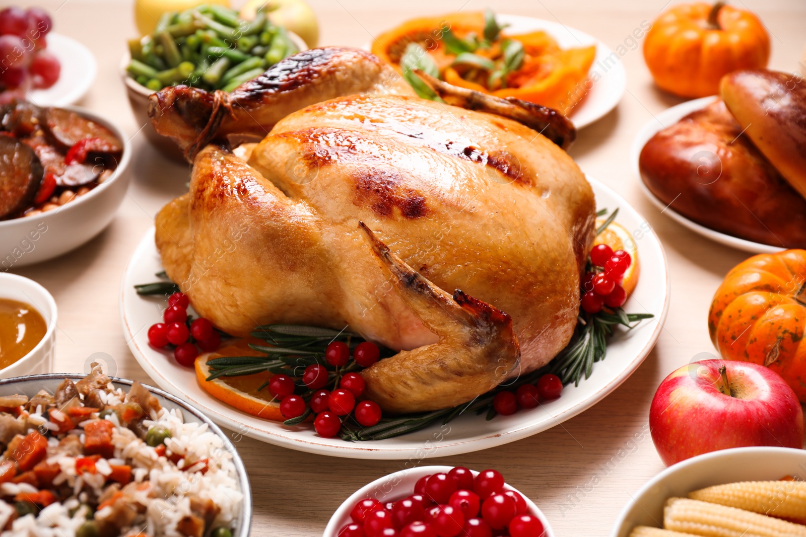 Photo of Traditional Thanksgiving day feast with delicious cooked turkey and other seasonal dishes served on wooden table