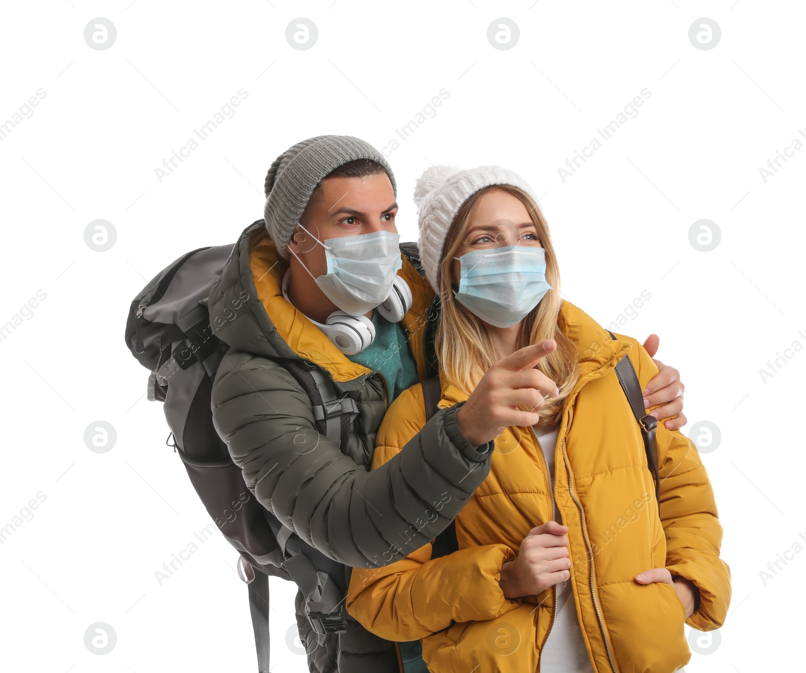 Photo of Couple in face masks and warm clothes on white background. Winter travel