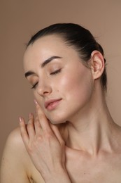 Photo of Portrait of beautiful young woman on light brown background