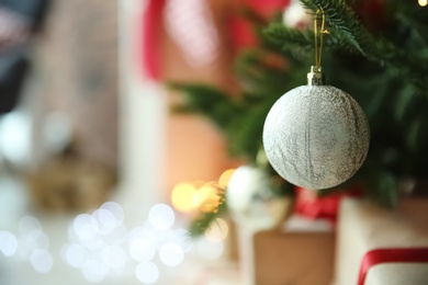 Photo of Shiny decoration on Christmas tree indoors, closeup