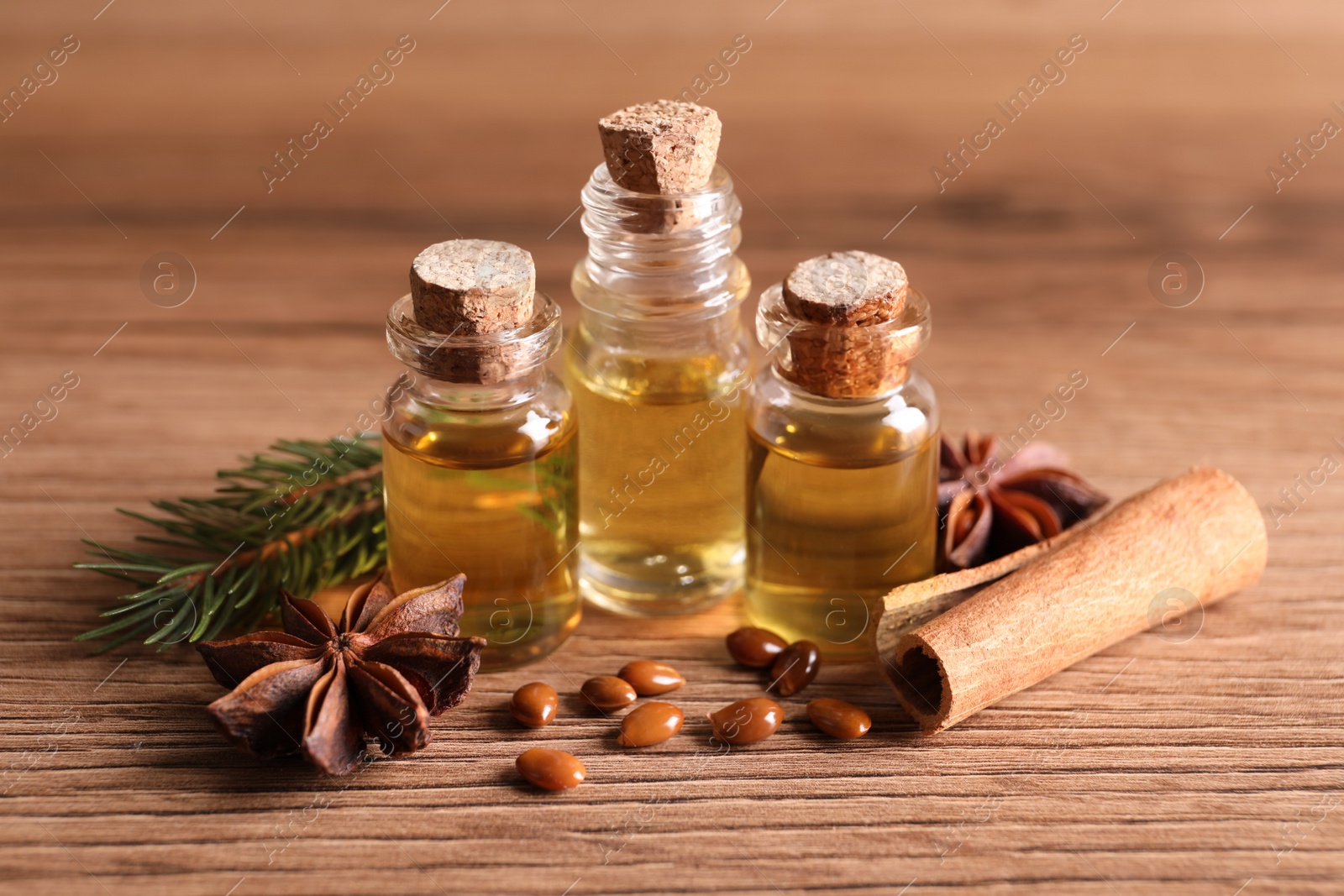 Photo of Anise essential oil and spices on wooden table