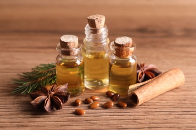 Anise essential oil and spices on wooden table