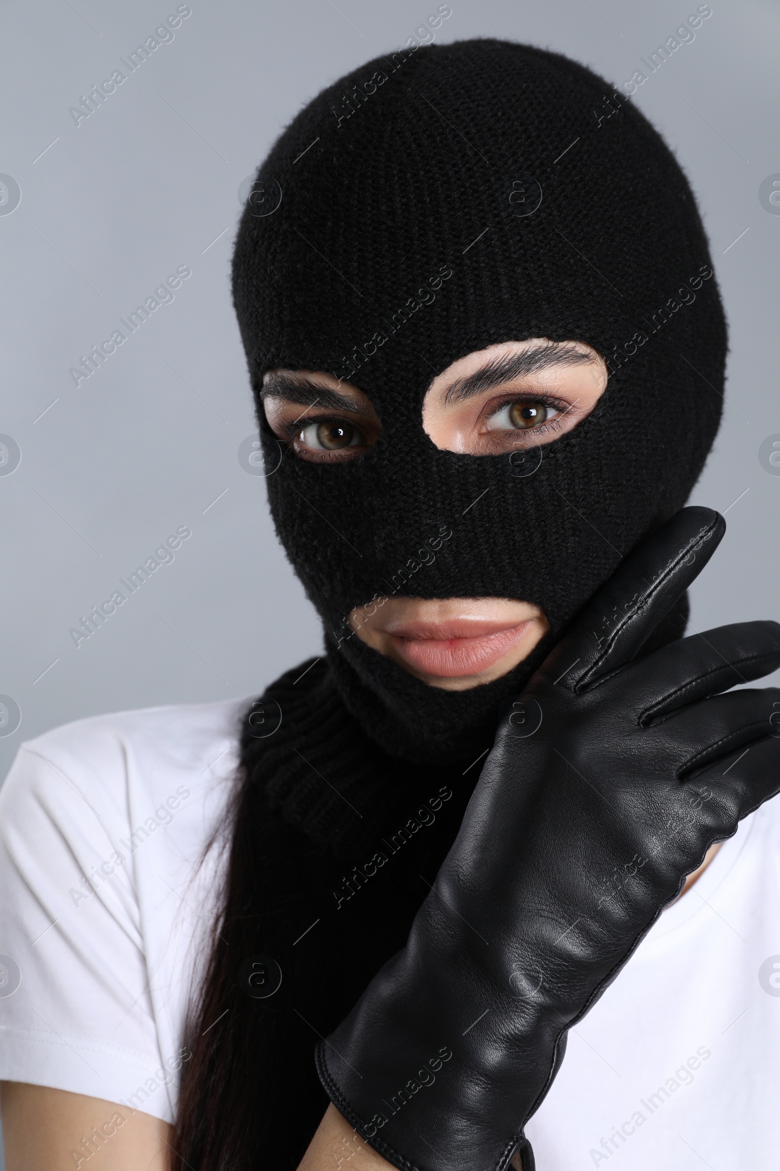 Photo of Woman wearing knitted balaclava on grey background