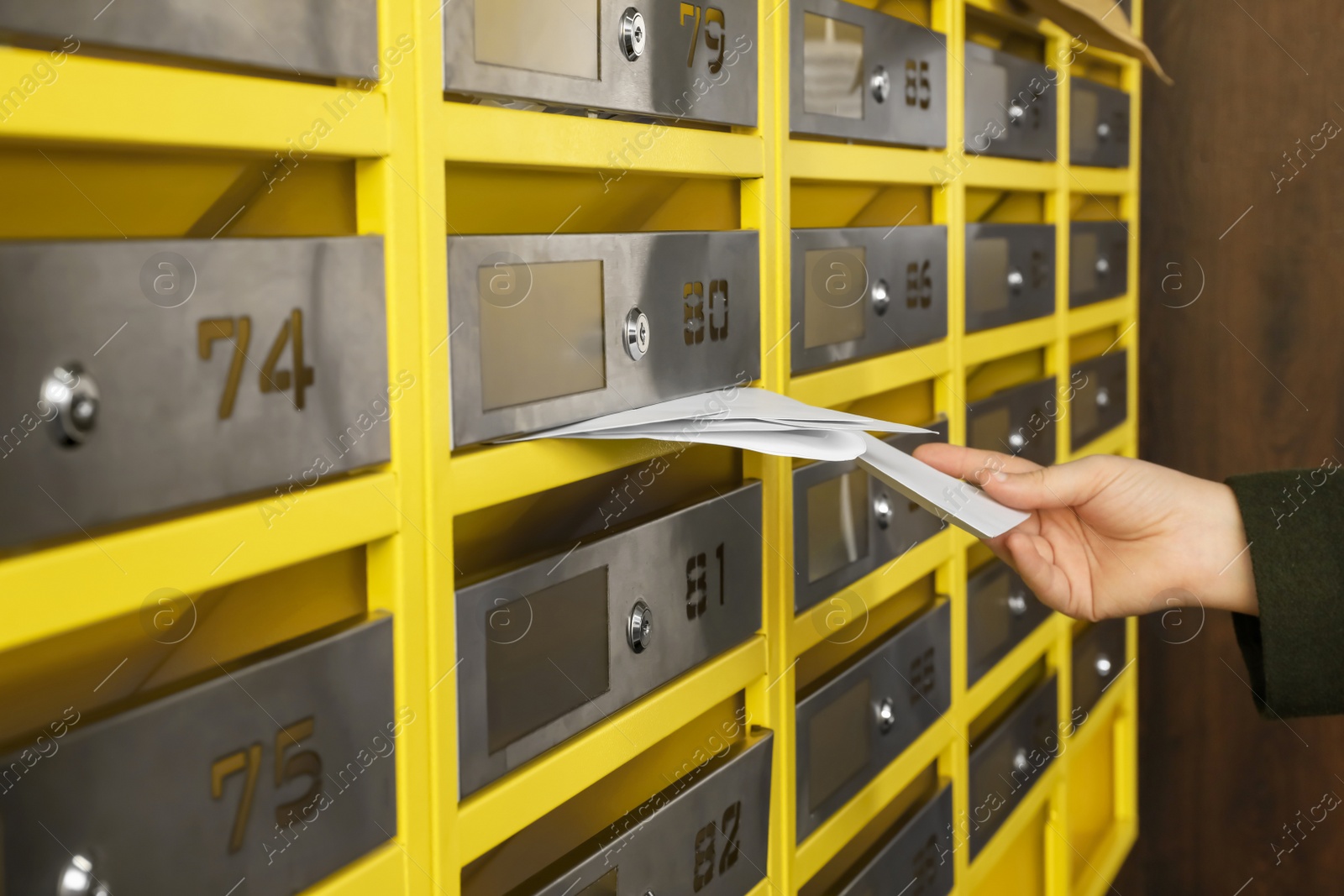 Photo of Woman taking envelopes out of mailbox in post office, closeup