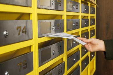 Photo of Woman taking envelopes out of mailbox in post office, closeup