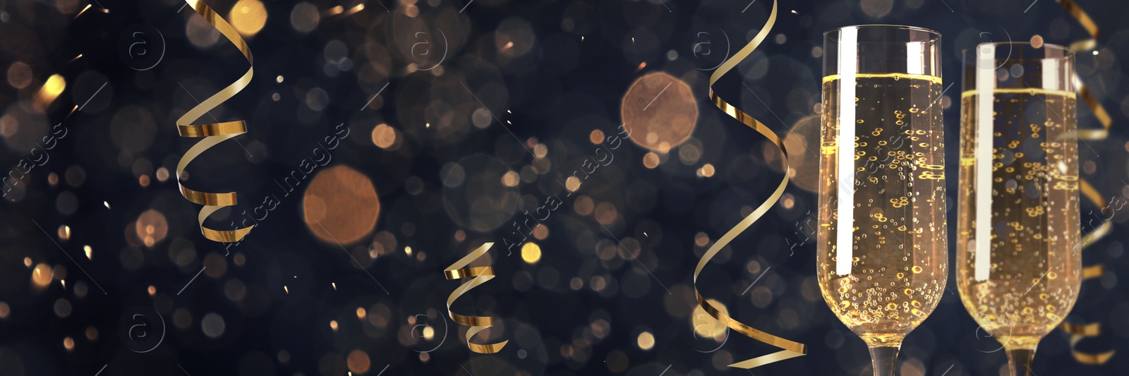 Image of Glasses with sparkling wine and shiny serpentine streamers against blurred festive lights, space for text. Banner design