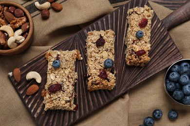 Photo of Tasty granola bars and ingredients on table, flat lay