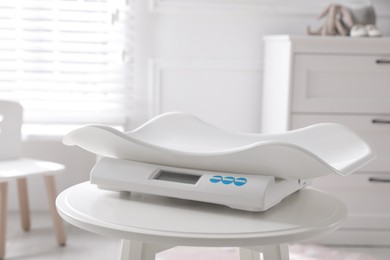 Modern digital baby scales on table in room