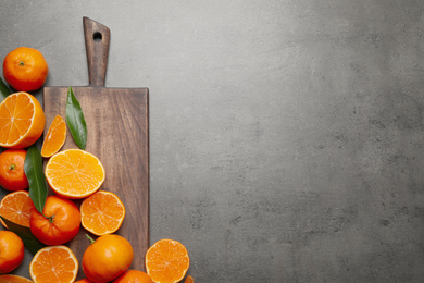 Fresh ripe tangerines and space for text on dark grey table, flat lay. Citrus fruit