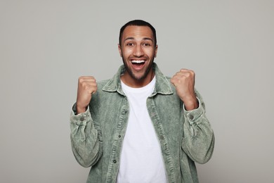 Portrait of happy African American man on light grey background