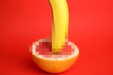 Image of Fresh grapefruit and banana on red background. Sex concept