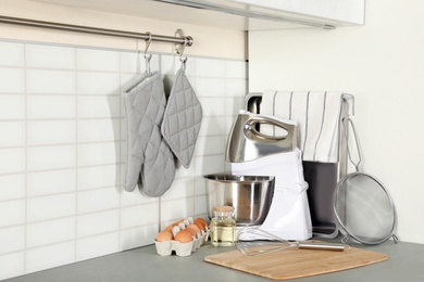 Set of clean cookware, utensils and eggs on table in modern kitchen