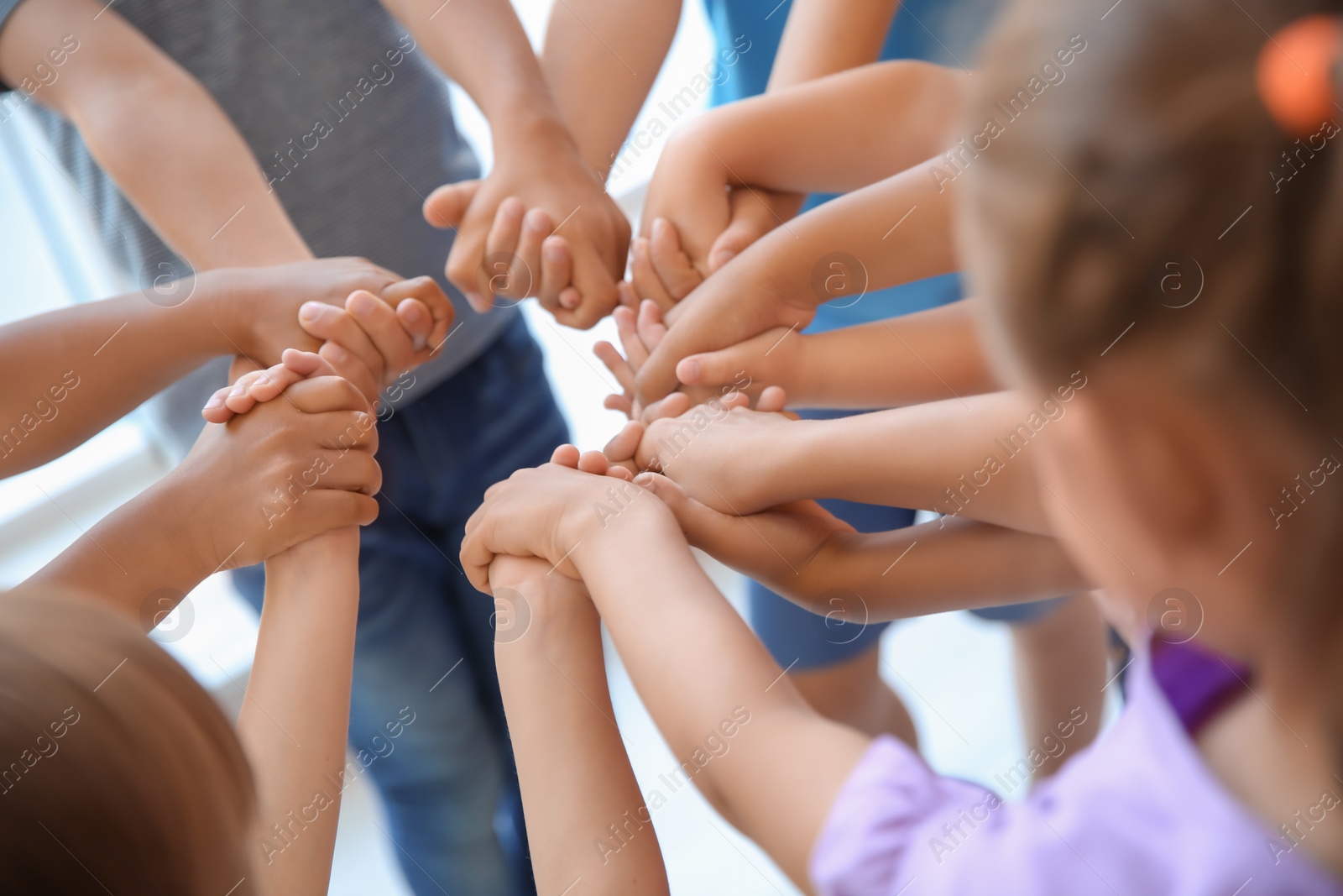 Photo of Little children holding their hands together, closeup. Unity concept