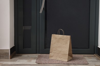 Photo of Paper bag on door mat near entrance indoors