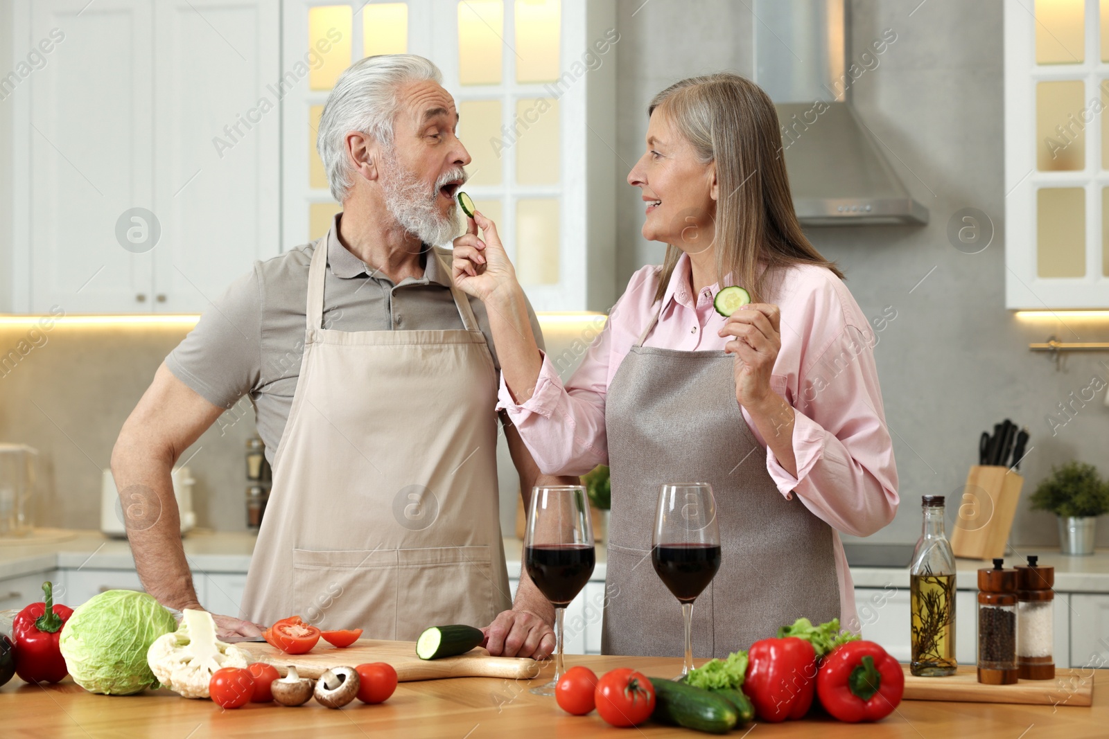 Photo of Happy senior couple cooking together in kitchen