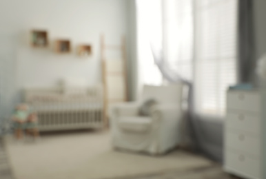 Blurred view of baby room with stylish furniture