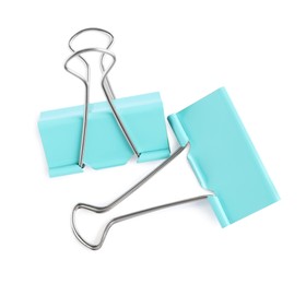 Photo of Turquoise binder clips on white background, top view. Stationery item