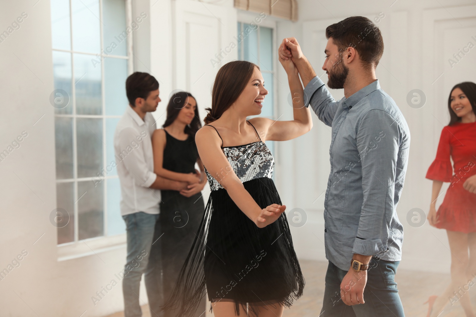 Photo of Lovely young couple dancing together at party