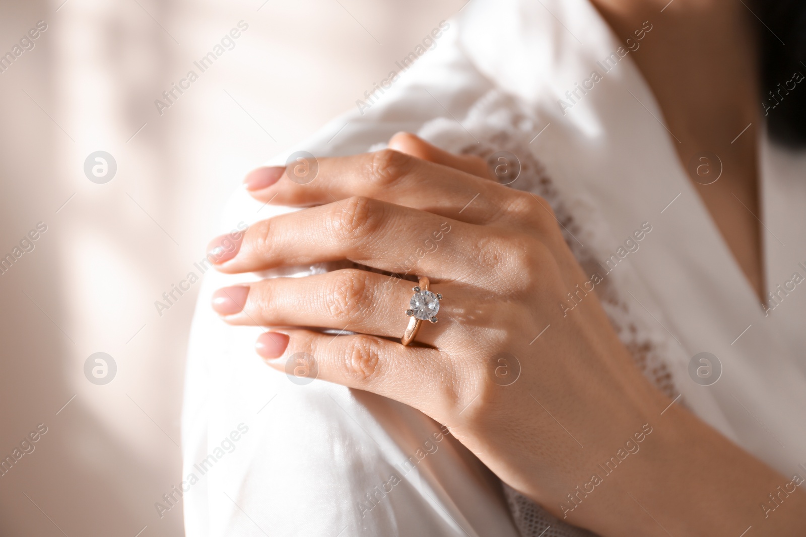 Photo of Young woman wearing beautiful engagement ring, closeup