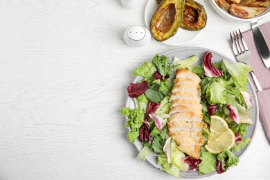 Photo of Tasty cooked chicken fillet with fresh salad  and space for text on white wooden table, flat lay. Healthy meals from air fryer