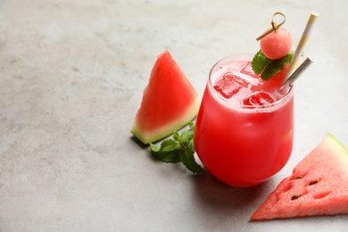 Photo of Delicious fresh watermelon drink on grey table. Space for text