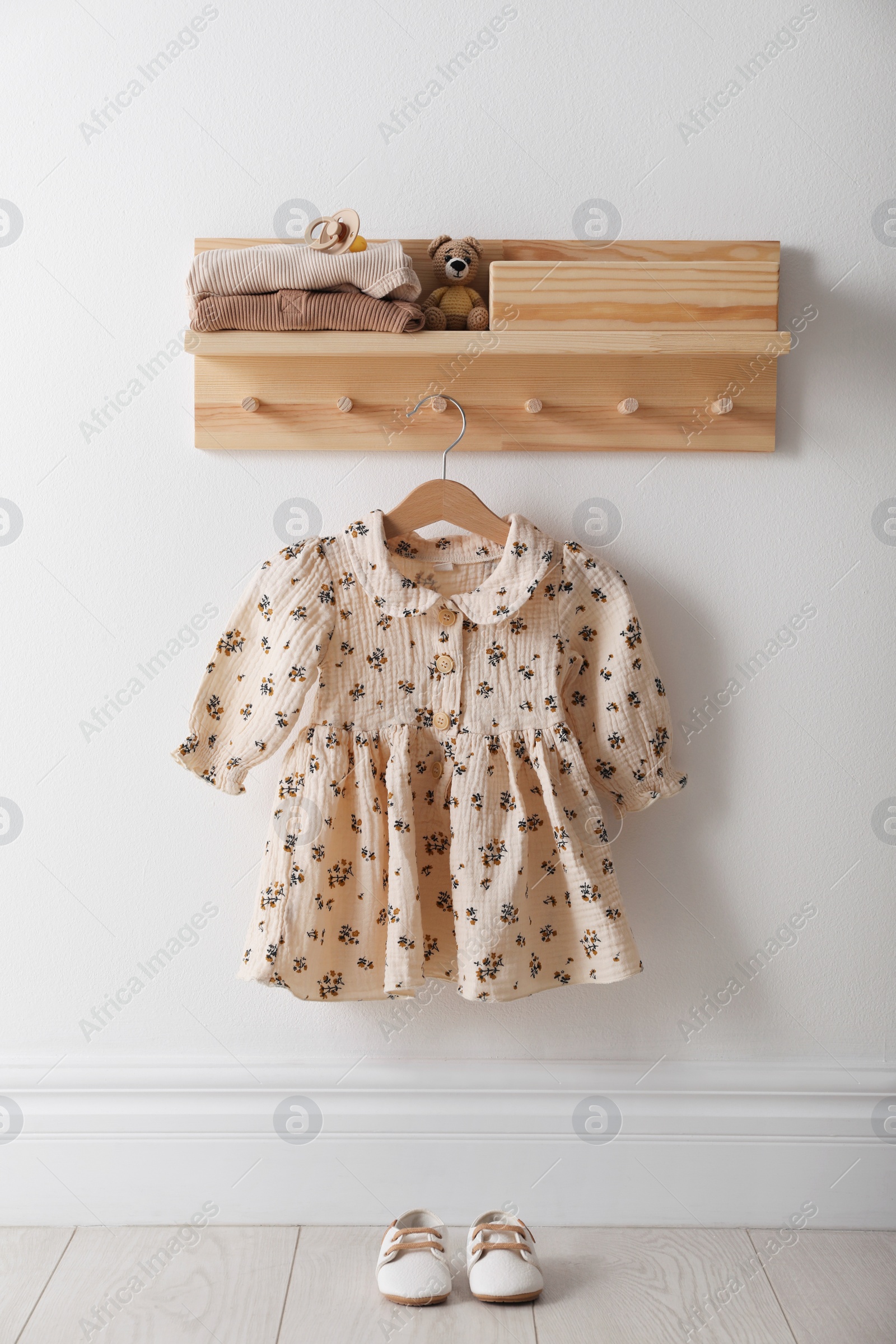 Photo of Cute children's clothes and shoes in room