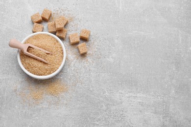 Photo of Different types of brown sugar on grey table, flat lay. Space for text