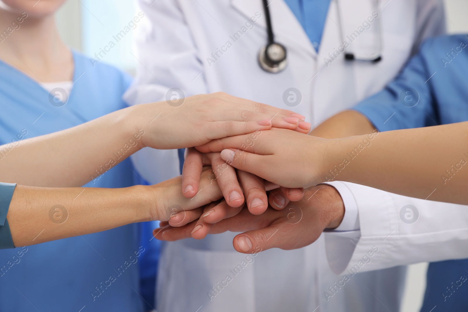 Photo of Team of medical doctors putting hands together, closeup