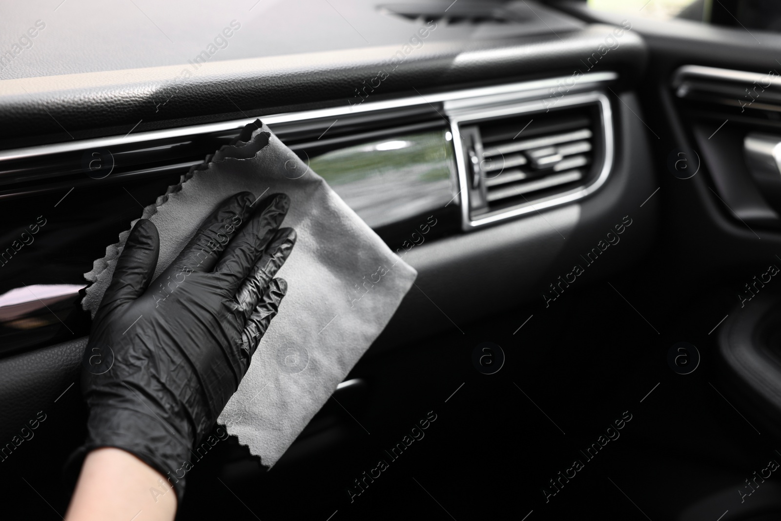 Photo of Woman wiping her modern car with rag, closeup