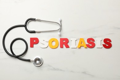 Photo of Word Psoriasis made of paper letters and stethoscope on white marble table, flat lay