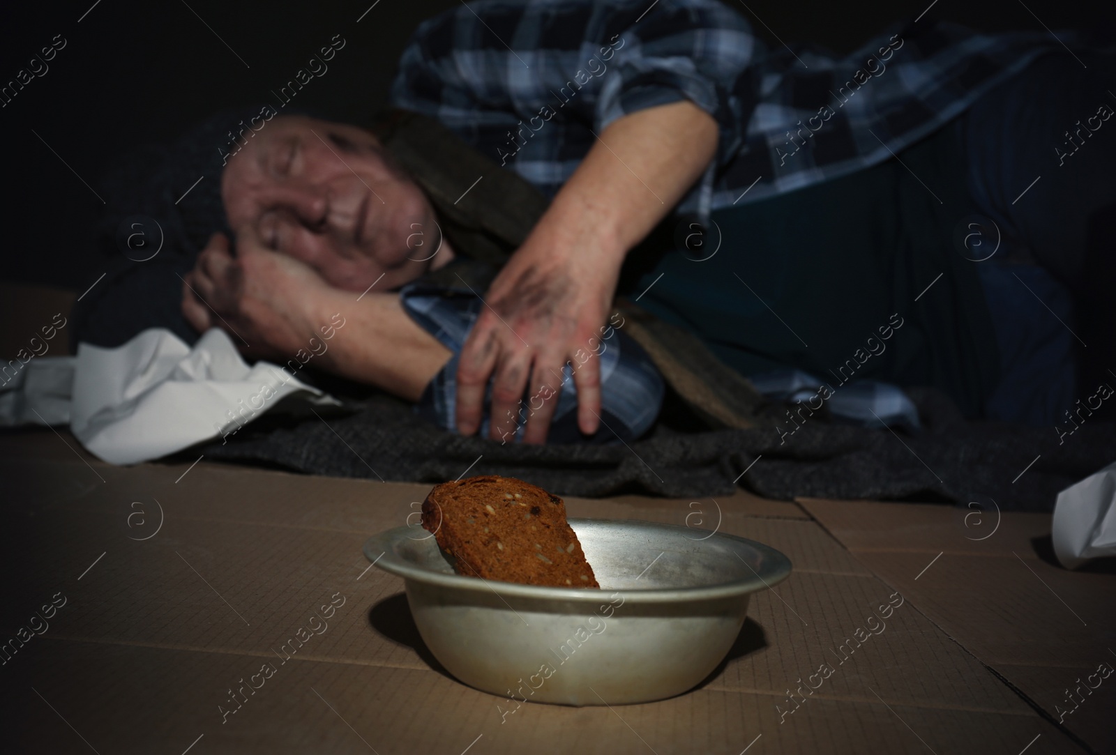 Photo of Bowl with bread and poor senior man on floor