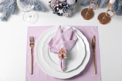 Photo of Stylish table setting with pink fabric napkin, beautiful decorative ring and festive decor on white background, flat lay