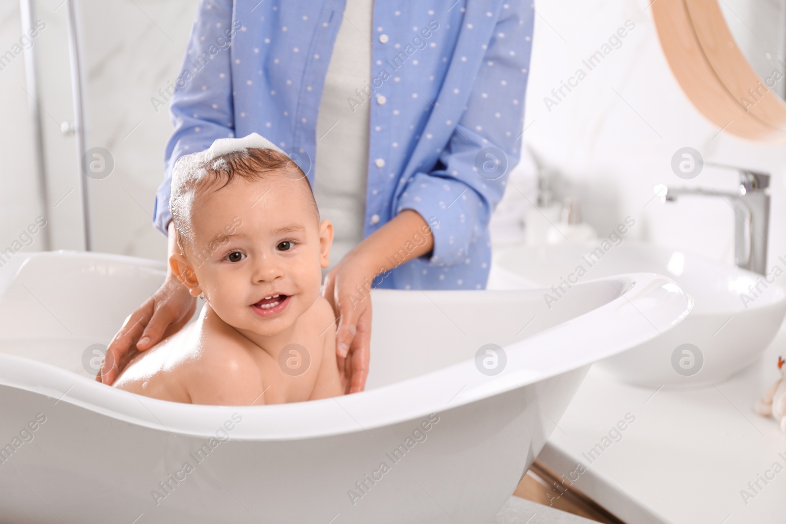 Photo of Mother with her little baby in bathroom