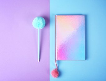 Photo of Stylish notebook with pompom and pen on color background, flat lay. Space for text