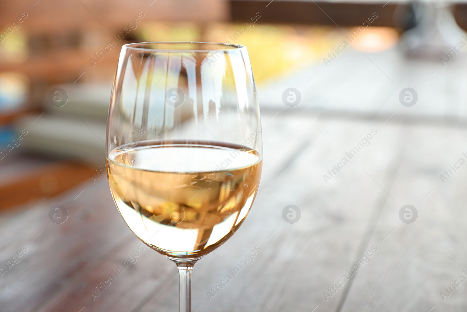 Photo of Glass of delicious white wine on blurred background, closeup. Space for text