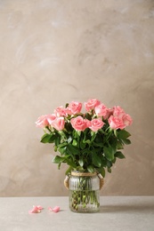 Vase with beautiful rose flowers on table