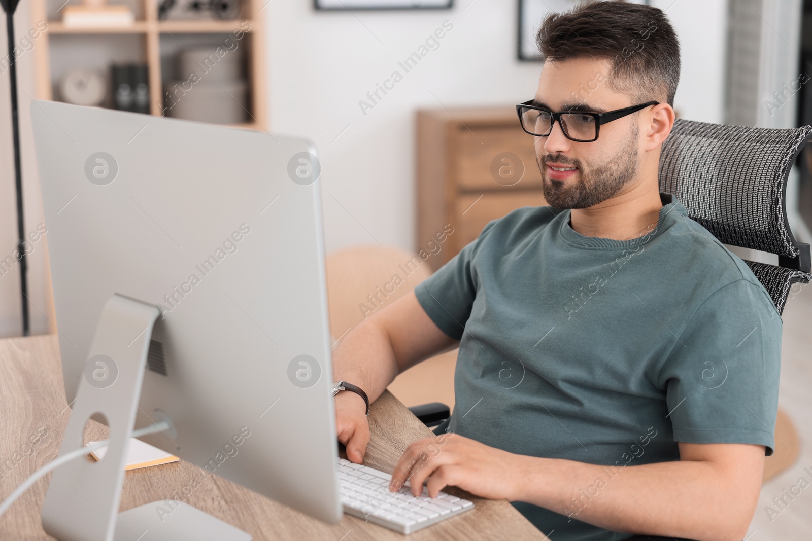 Photo of Programmer working with computer at desk in office