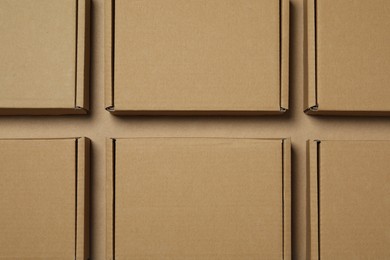 Many closed cardboard boxes on light brown background, flat lay